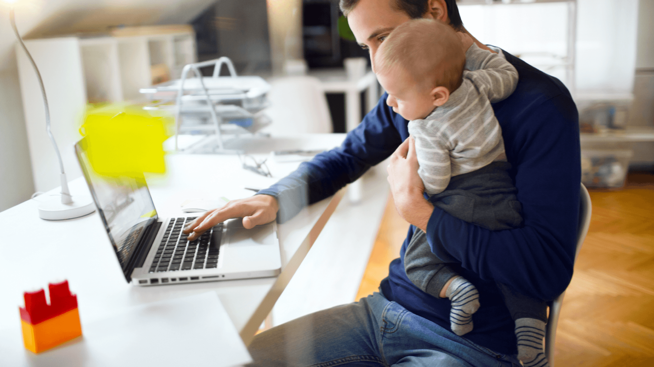 Adult showing laptop to  baby.