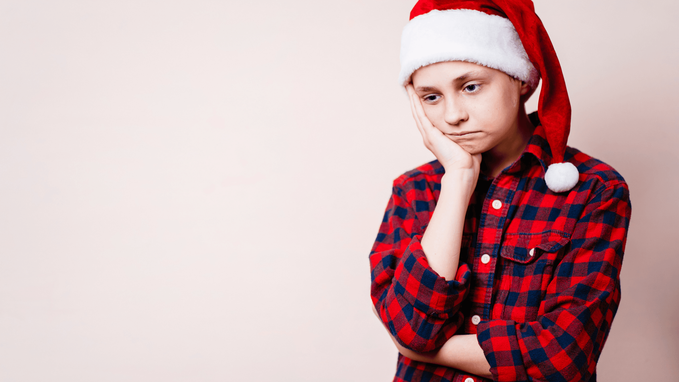 Bored child wearing santa cap