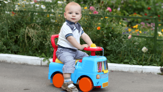 a kid siiting on a toy vehical